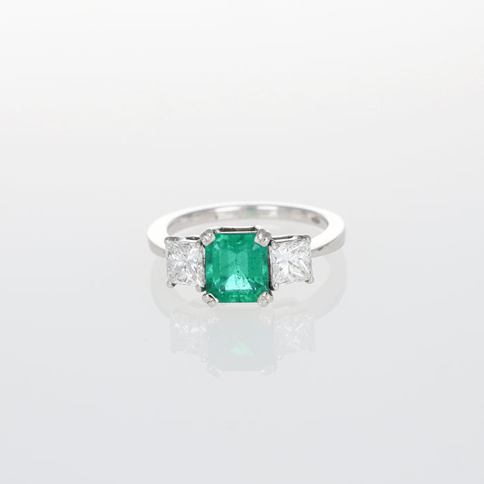 Anello in Oro Bianco 18kt con Smeraldo Centrale e Diamanti Princess Laterali
