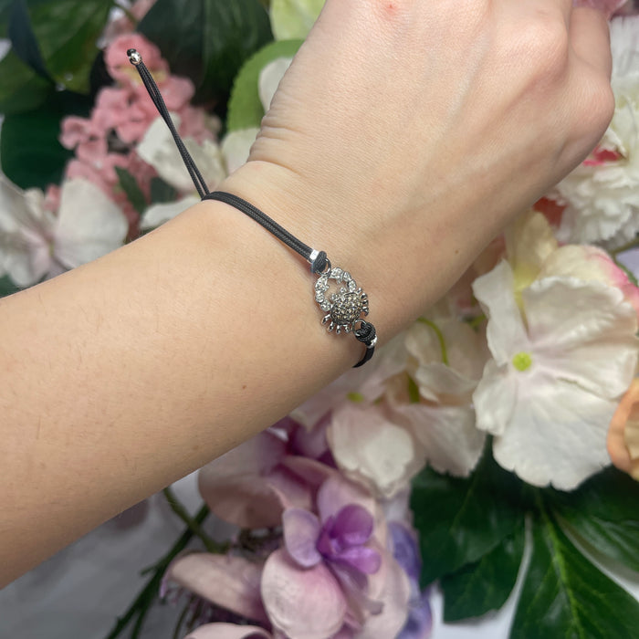 Bracciale con Cordino Nero, Charm Granchio in Oro Bianco e Diamanti Brown e Bianchi