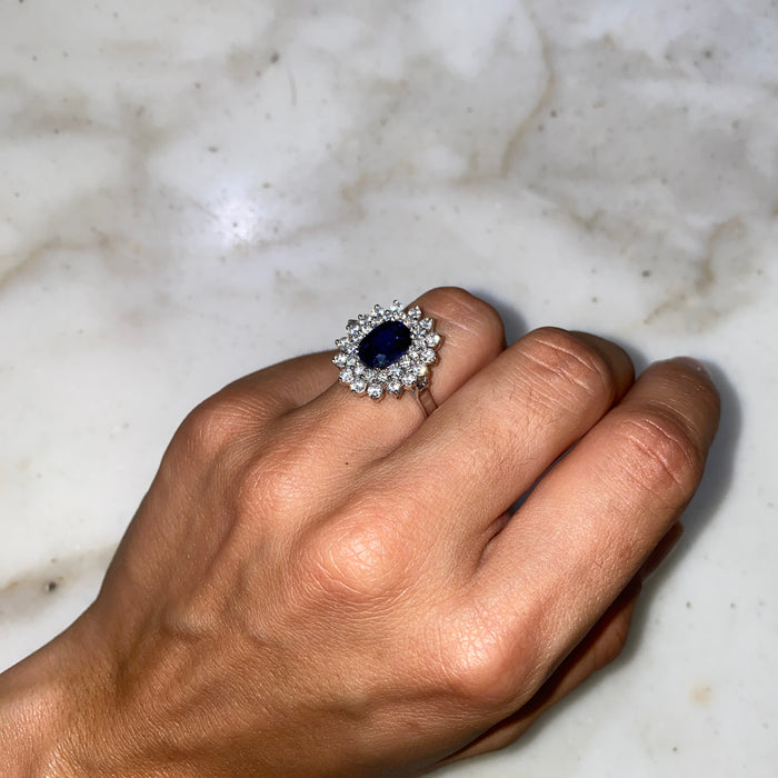 Anello in Oro Bianco con Zaffiro Blu Ovale e Doppio Contorno di Diamanti